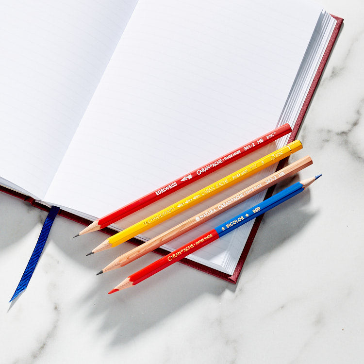 Caran d'Ache pencils sitting on top of a Write Notepads & Co. Classic Hardcover Notebook Lined