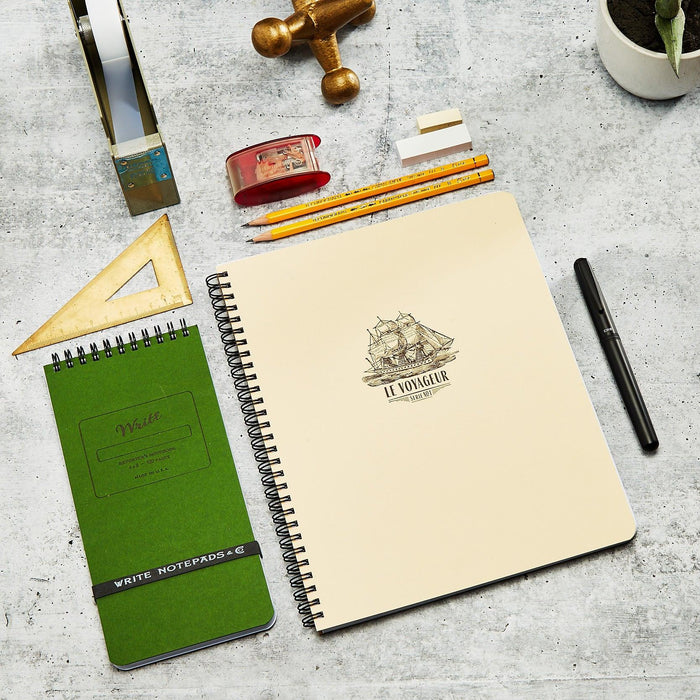 Le Voyageur on a desk with a Reporter Notebook 