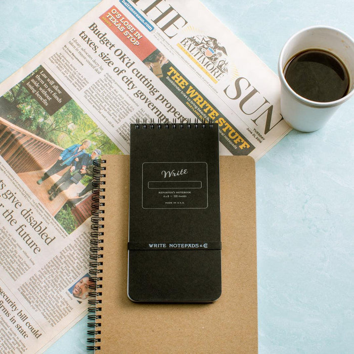 reporter notebooks on desk in hand